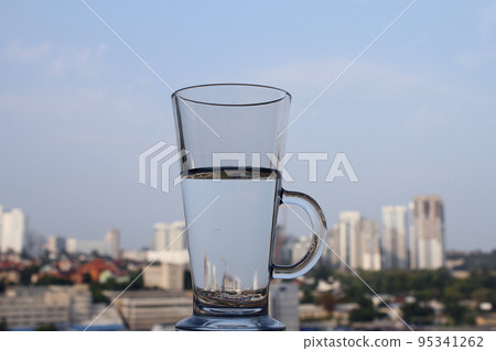 City buildings reflected in glass of water with soft focus cityscape background City buildings reflected in glass of water with soft focus cityscape background 95341262