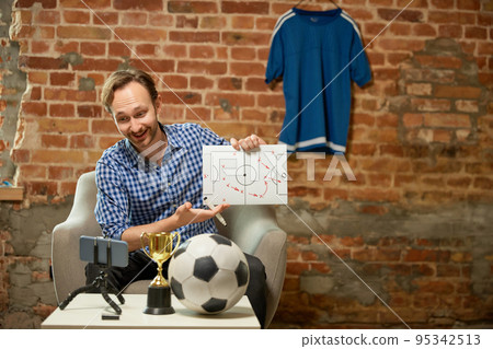 Happy man, soccer fan recording vlog about last football match and shares his opinion on the strategy of the game. Sport, hobby and leisure concept. 95342513