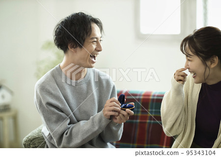 Young man proposing in the living room 95343104