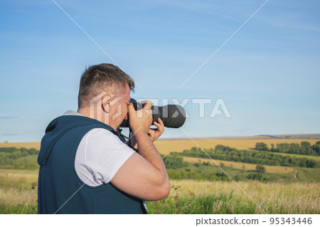 Photographer takes a rural landscape on camera 95343446