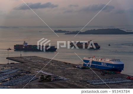 [Logistics] Car carrier docked at a container terminal early in the morning 95343784