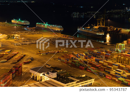 [Logistics] Car carrier docked at a container terminal Night view 95343787