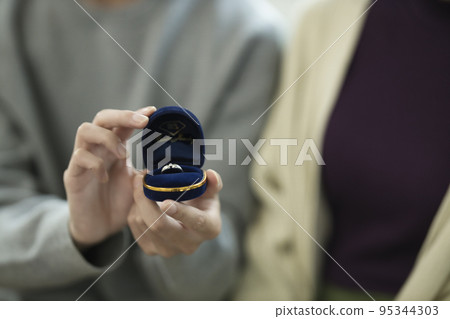 Young man proposing in the living room Young man proposing in the living room 95344303