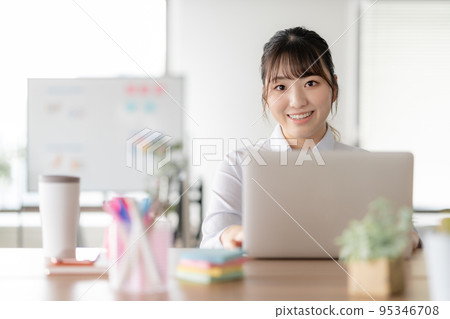 A young woman working on a computer in the office A young woman working on a computer in the office 95346708