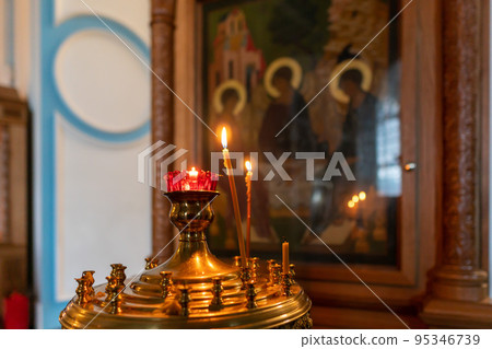 Burning candles in a Christian Orthodox church Burning candles in a Christian Orthodox church 95346739