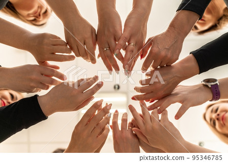Team of people holding hands. Group of happy young women holding hands. Bottom view, low angle shot of human hands. Friendship and unity concept 95346785