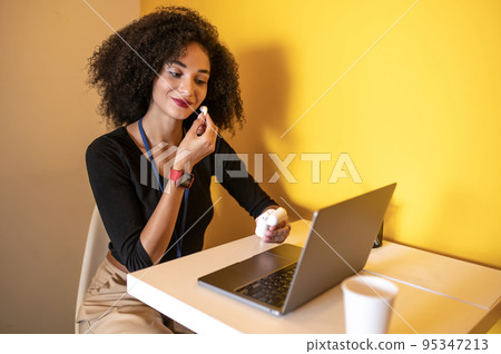 Curly-haired young woman putting on wireless earphones Curly-haired young woman putting on wireless earphones 95347213