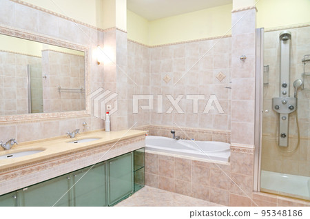 Clean bathroom in a hotel room with bath and shower. 95348186