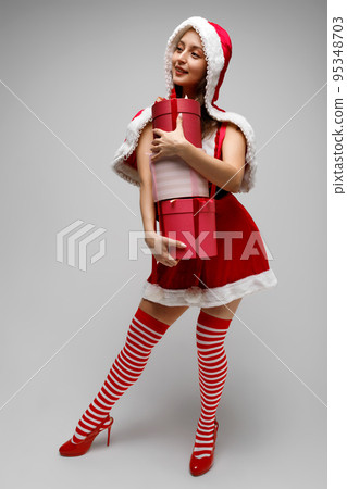 Beautiful happy woman holding a Christmas gift Beautiful happy woman holding a Christmas gift 95348703