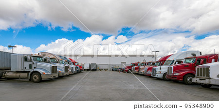 Semi-trailers lined up at a warehouse berth 95348900
