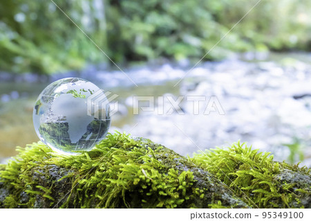 A clear stream flows in the background of a crystal globe centered on Africa 95349100