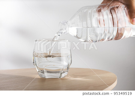 Pouring water into glass Pouring water into glass 95349519