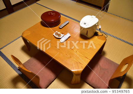A guest room in an inn with a low table and chairs 95349765