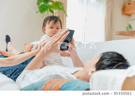 Daddy ignores his family and looks at his phone 95350561