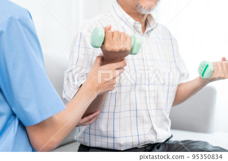 Contented senior patient doing physical therapy with the help of his caregiver. Contented senior patient doing physical therapy with the help of his caregiver. 95350834