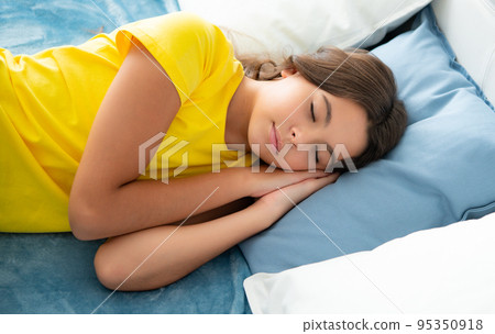 Kid lying and sleeping on bed. Child teen sleeps in the bed. Teenager sleep in bed on pillows at home. Kid lying and sleeping on bed. Child teen sleeps in the bed. Teenager sleep in bed on pillows at home. 95350918