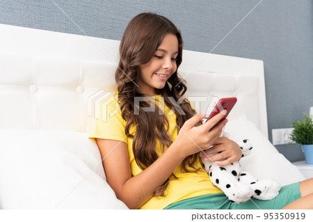 Spending some time in chatting. Happy child chat on mobile phone. SMS chat. Text messaging Spending some time in chatting. Happy child chat on mobile phone. SMS chat. Text messaging 95350919