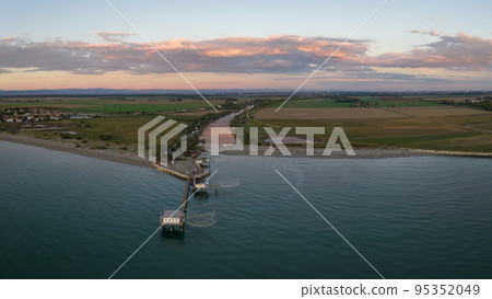 Beautiful aerial view of typical fishing huts at sunset near Comacchio Beautiful aerial view of typical fishing huts at sunset near Comacchio 95352049