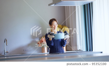A housewife cooking in a casting enamel pot A housewife cooking in a casting enamel pot 95352100