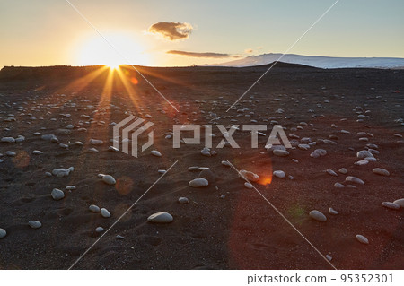 Iceland landscape black sand beach with stones and sunset flare Iceland landscape black sand beach with stones and sunset flare 95352301