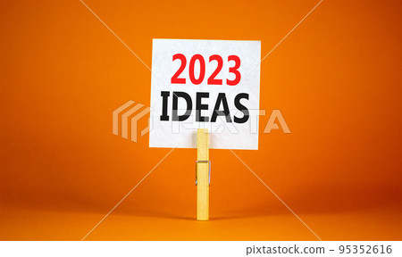 2023 Ideas symbol. White paper with words 2023 Ideas, clip on wooden clothespin. Beautiful orange table orange background. Business and 2023 ideas concept. Copy space. 2023 Ideas symbol. White paper with words 2023 Ideas, clip on wooden clothespin. Beautiful orange table orange background. Business and 2023 ideas concept. Copy space. 95352616