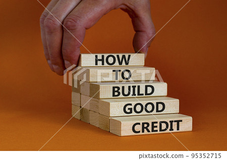 Build good credit symbol. Wooden blocks with words How to build good credit. Businessman hand. Beautiful orange background, copy space. Business and build good credit concept. Build good credit symbol. Wooden blocks with words How to build good credit. Businessman hand. Beautiful orange background, copy space. Business and build good credit concept. 95352715
