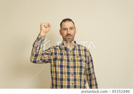 Happy successful bearded businessman winning, fist raised celebrating success isolated beige wall background. Positive human emotion facial expression. Perception of life, achievement. Happy successful bearded businessman winning, fist raised celebrating success isolated beige wall background. Positive human emotion facial expression. Perception of life, achievement. 95352890