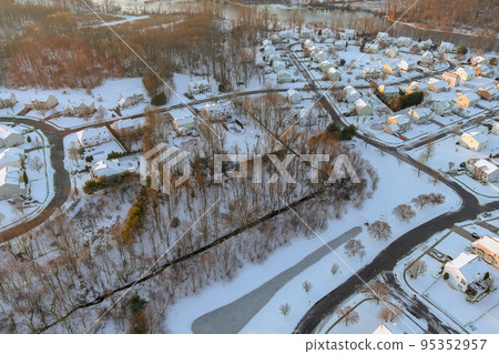 Snow covered landscape of snowy winter landscape around American town home complex near small river residential streets after snowfall 95352957