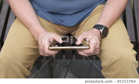 Gambling addiction. Close-up of modern smartphone in hands of adult man actively pressing on-screen buttons in computer game. Online casino, gambling Gambling addiction. Close-up of modern smartphone in hands of adult man actively pressing on-screen buttons in computer game. Online casino, gambling 95353764