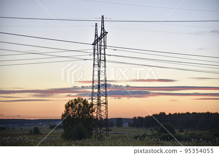 Beautiful high-voltage iron transmission line in the evening in the sunset sky. Landscape evening and wires and power lines. Beautiful high-voltage iron transmission line in the evening in the sunset sky. Landscape evening and wires and power lines. 95354055