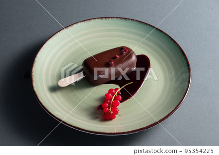 cake pop dessert or ice cream covered with chocolate on plate in restaurant 95354225