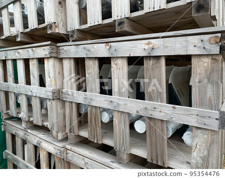Wooden boxes with materials and pipes are stored in a warehouse with industrial equipment Wooden boxes with materials and pipes are stored in a warehouse with industrial equipment 95354476