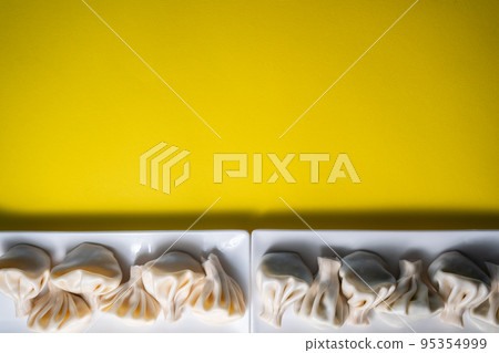 traditional georgian khinkali dumplings flatlay, copyspace, yellow background 95354999