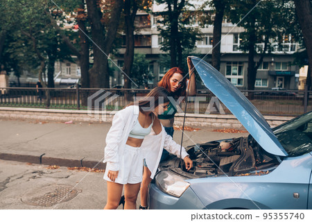 Two women with broken car on the road. Open hood Two women with broken car on the road. Open hood 95355740