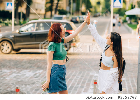Two students high five to teach others after successful work together Two students high five to teach others after successful work together 95355768