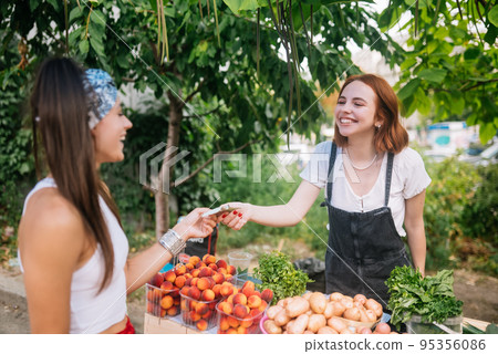 Seller woman offers fresh and organic vegetables farmers market. 95356086