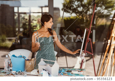 Young beautiful female artist with tools posing for camera Young beautiful female artist with tools posing for camera 95356123