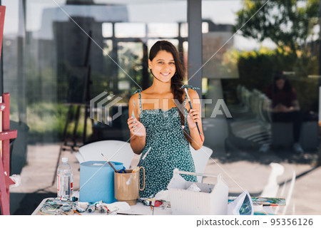 Young beautiful female artist with tools posing for camera 95356126