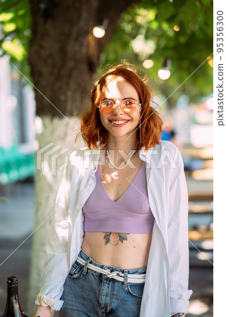 Young woman with toothy smile in outdoors Young woman with toothy smile in outdoors 95356300