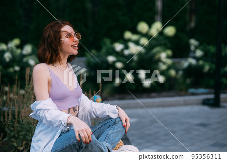 Young red-haired woman sitting in lotus position Young red-haired woman sitting in lotus position 95356311