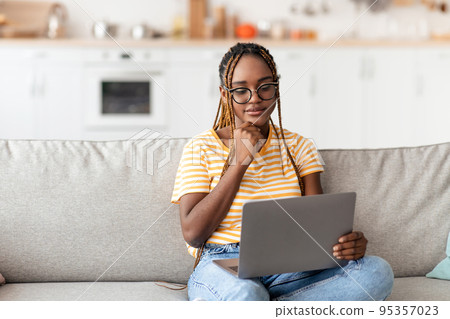 Attractive african american woman using notebook at home 95357023