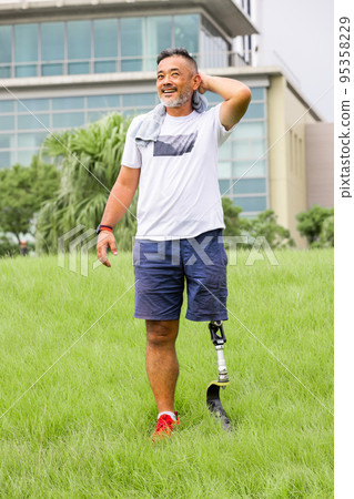 Disabled man with prosthetic leg exercising Disabled man with prosthetic leg exercising 95358229