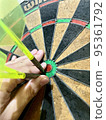 A hand pulling out a stuck dart 95361792