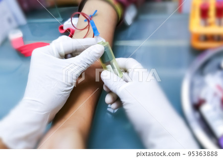 Phlebotomist collects blood in hospital for biochemical analysis. 95363888