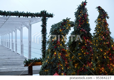 New Year and Christmas decorations on the seashore in winter. Yalta. Ate in garlands and beads. Front view. New Year and Christmas decorations on the seashore in winter. Yalta. Ate in garlands and beads. Front view. 95364227