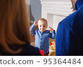 Adorable baby boy waiting gift from parents 95364484