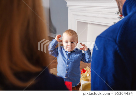 Adorable baby boy waiting gift from parents 95364484