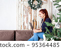 Young woman working from home. Christmas time.  95364485