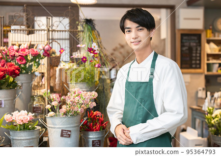 Young man working in a flower shop 95364793