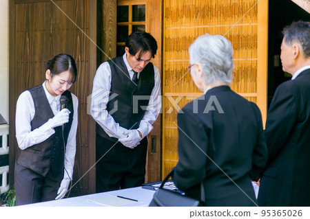 殯儀館主任(主持人)在葬禮招待會上鞠躬 殯儀館主任(主持人)在葬禮招待會上鞠躬 95365026